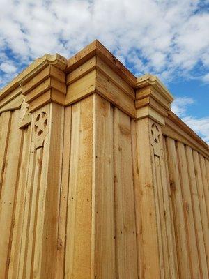 Cedar board on board fence with double trim, false fluted columns, decorative star design with a top cap.