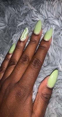 Green almond nails with squiggly design on ring finger