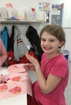 Anna eating a cupcake on the Valentine's Day party