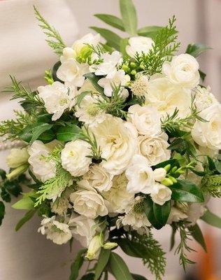 Bridal bouquet of white roses, white ranuculus, berries and fern