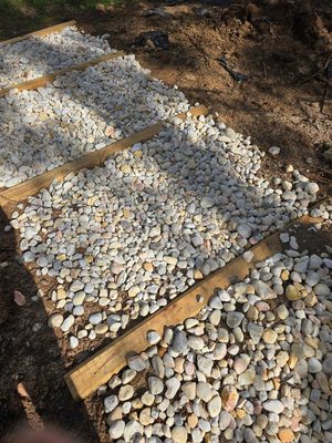 Landscape timbers and river rock on a slope.