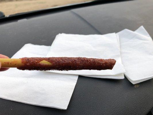 Plastic straw wrapped with sweet, salty and spicy tamarind around the outside of the straw.