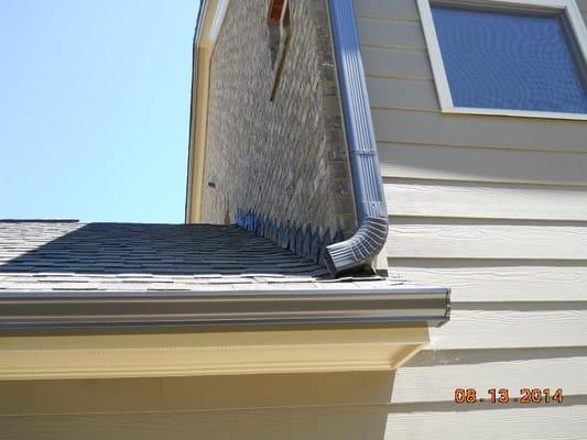 I don't like to see downspouts dumping out onto a roof. This increases wear on the roof materials. 