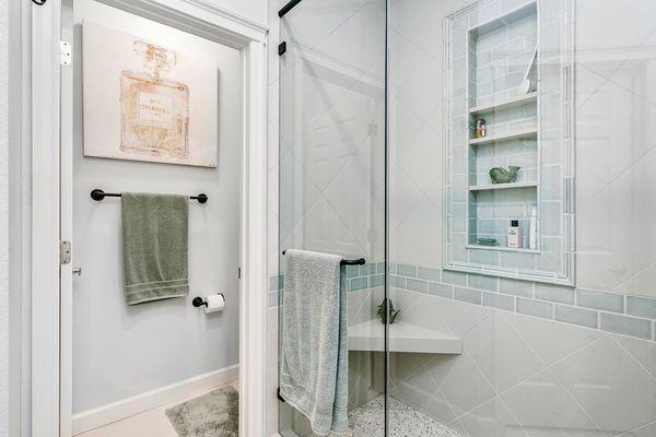 Custom tile niche and bench in enlarged walk-in shower - Meridian whole home renovation