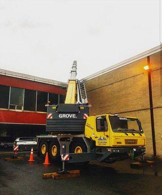 A GMK 3050B hoisting material to a rooftop