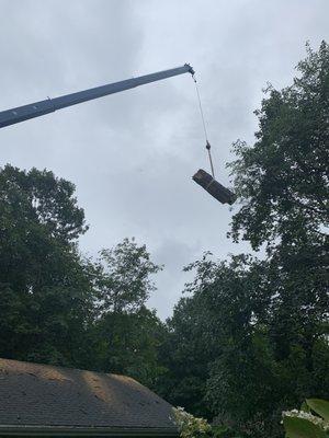 Crane lifts tree from neighbor's backyard over our house.