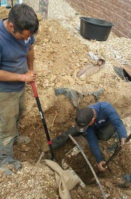 Here's the guys located the damaged pipe.   In back, on the upper right (beneath the board), is the access point to the other tank.