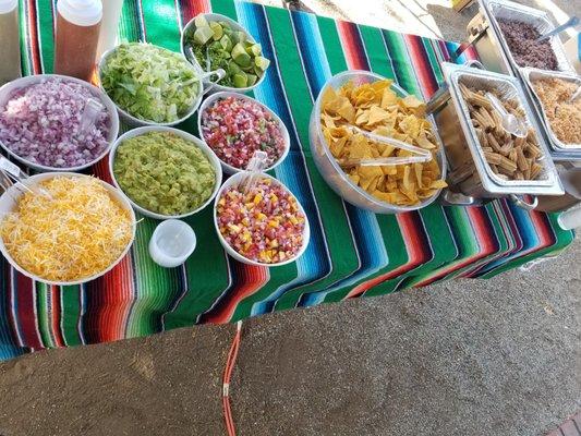 Our Taco bar buffet with Salsas, Cheese, Guacamole, Mango pico de Gallo, Regular Pico De Gallo, Lettuce, Onions, limes, Churros, Rice Beans