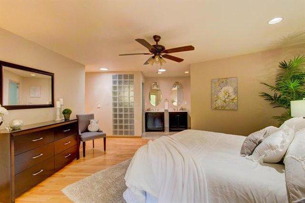 A beautiful white bedspread lays the foundation for a warm and gorgeous master suite.