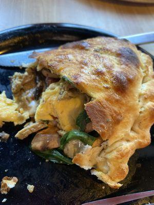 Breakfast calzone with egg cheese mushroom spinach bacon and meatball.