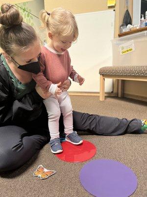 Maisie learning how to jump with her therapist Delaney.