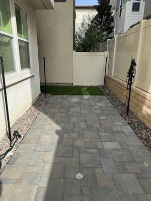 Pavers with turf. Rocks around the perimeter to fill with landscaping later.