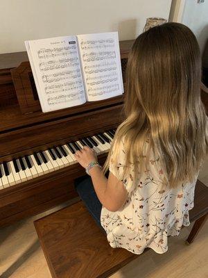 Charlotte playing on her new piano with her skills thanks to Miss Kristina