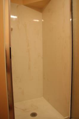 New cultured marble  on walls and custom cultured shower base. Also added a custom made shower door.