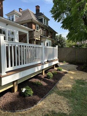 New plants and decorative flower beds around the new deck.