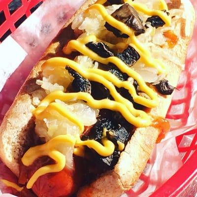 hot dog named FACTS turkey halal, onion sauce, sauerkraut, mushrooms and spicy nacho cheese.