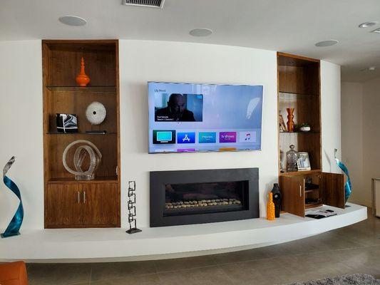 75" 4K TV over a fireplace on a full-motion wall mount with AV equipment located inside cabinet. (Palm Springs).