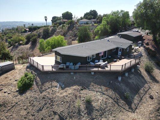 this is a custom hillside deck built with presure treated deck support system , timber tech decking and trex transend rails