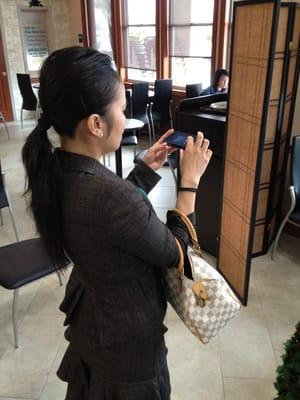 Taking a pic of the ceiling artwork using her front-facing camera.