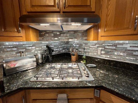 New backsplash on back wall as well as intermediate wall under the range hood.