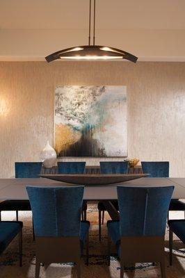 This dining room has stunning contemporary art hung on a textured artistic wall finish from Surface Refinements.