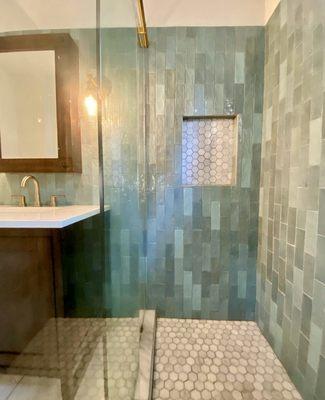 Brass against the green tile makes a perfect match.