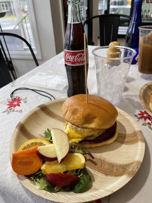 Egg and cheese sandwich, fresh fruit on the side and a Mexican coke.