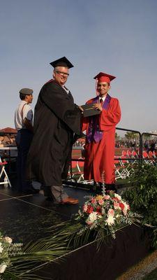 High School Senior Fernando Rodriguez Jr. (Class of 2016) handshaking Principal Joe Austin while receiving his high school diploma.