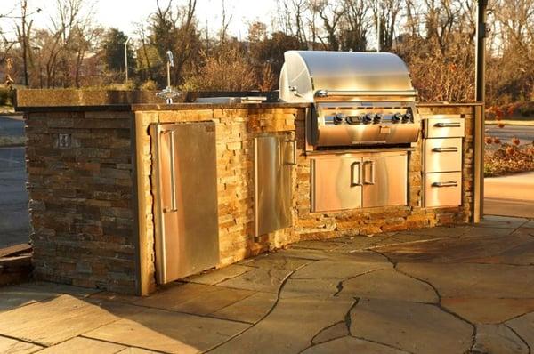 Outdoor kitchen island with Fire Magic Diamond Echelon grill, sink, side burner, refrigerator, and drawers.