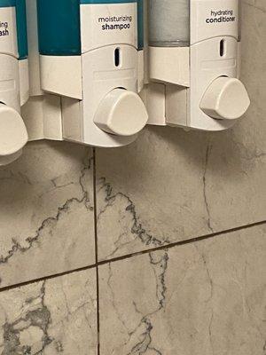 Check out the dispenser you are supposed to shower with?Perfect pairing to the tile filth .