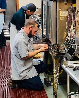 Our Service Expert repairing commercial kitchen equipment.