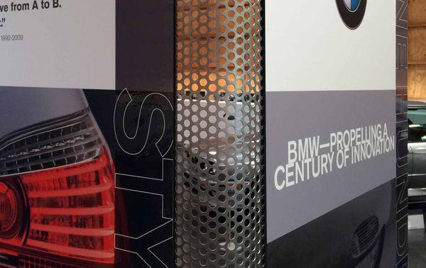 Close up of two standees joined by an architectural mesh designed for the American Car Museum exhibit