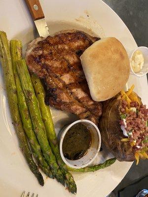 French pork chop, asparagus and loaded baked potato with muscadine glaze