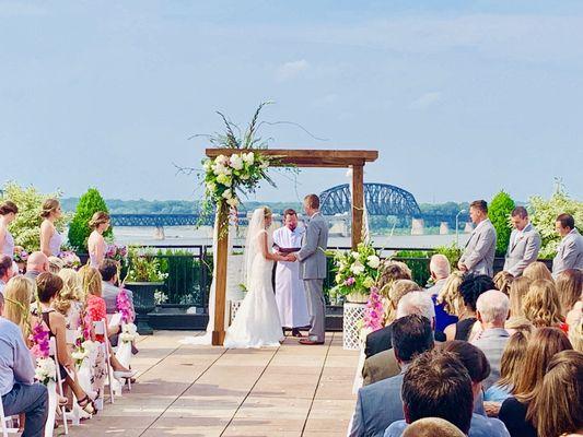 A wedding taking place on top of Frazier museum in downtown Louisville....The Ohio River and K & I bridge in background...