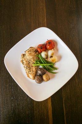 Herb Roasted Chicken, fingerling potatoes, french green bean, pearl onion with scorched tomato.