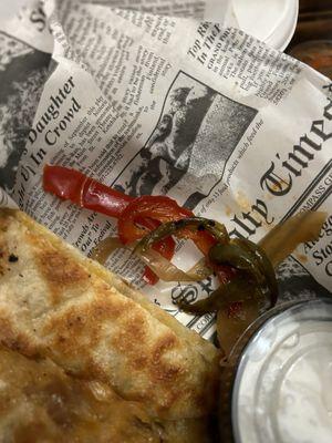 Chicken and cheese quesadilla with alot of peppers and onions.