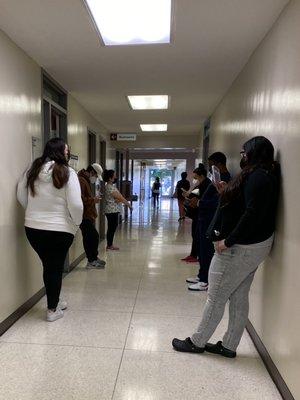 Both the waiting room and hallway are full of patients waiting.