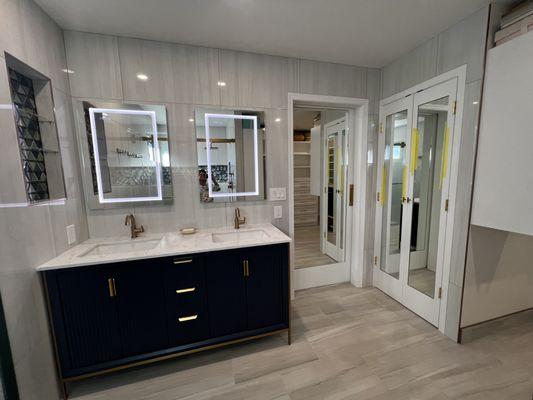 Mirrored barn door, french door to the bathroom closet, LED medicine cabinets, tiled walls and floor