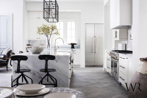 This elegant kitchen with waterfall quartz countertops and a herringbone tile floor is the highlight of a Winter Park home we just designed.