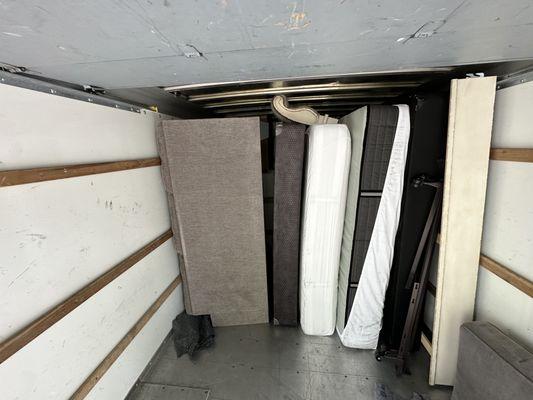 2 mattress sets and a couch being moved.