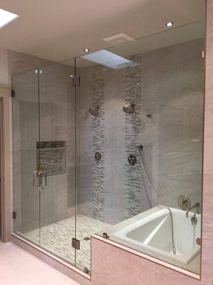 A frame-less shower we installed with two doors and a notched panel!