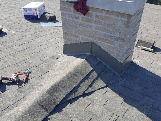 They added a cricket to keep the rain water away from the chimney and flashing.