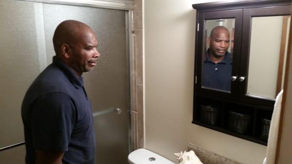 Charlie Biggins inspecting finished bathroom remodel