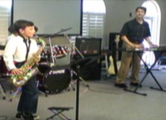 7 years old and playing Sax in a band at the Fall recital. He's got a great sense of humor too!