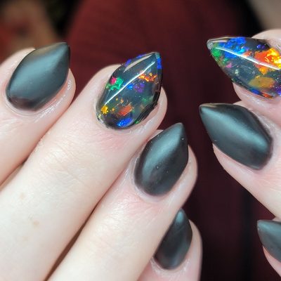 Matte black kitten nails with black opal accents.