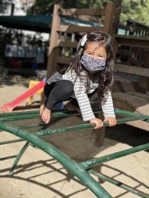 The play yard has a play structure, swings, climbing structures, a fire house structure, a mud kitchen, and "the river!"