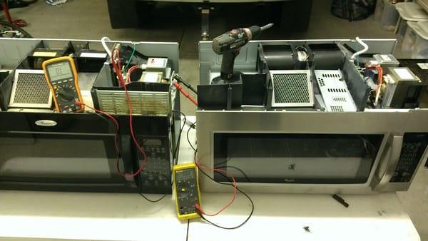 Appliance repair performed on a microwave. In this picture, one is being fixed.  The other, an organ donor.