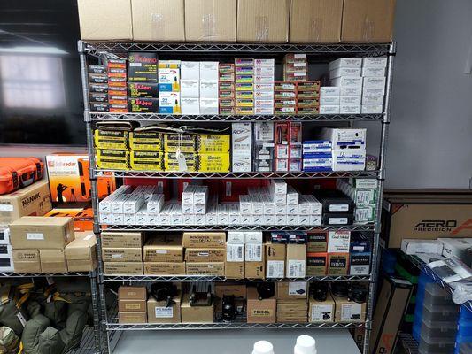 Tons of reloading supplies - dies, bullets, primers, and powder. Match ammo and tripod gear also pictured (top and bottom shelves).