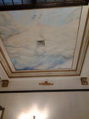 Beautiful clouds painted on the ceilings with a large sky light and chrystal chandeler.