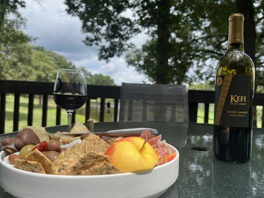 Small charcuterie platter with a bottler of Negro Amaro wine on the tasting room deck.